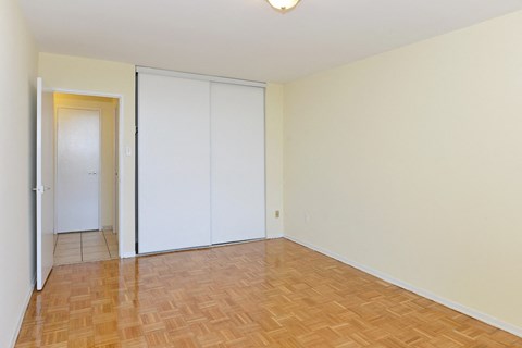 an empty living room with a door to a closet